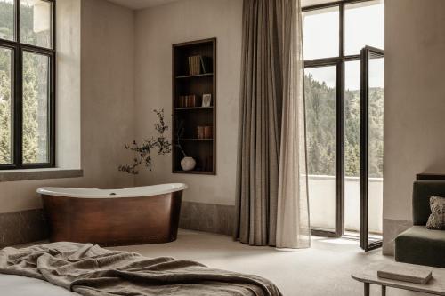 瓦尔特西尼科MANNA的一间带浴缸和大窗户的卧室