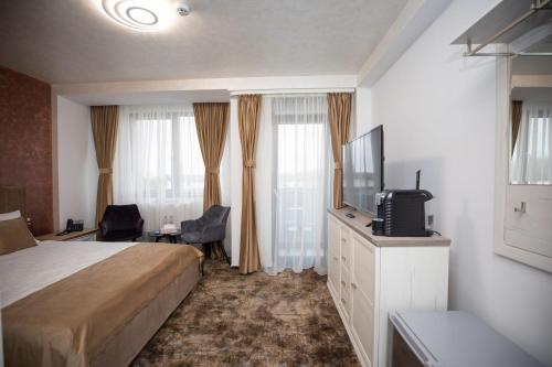 特尔戈维什泰Hotel Del Ponte的配有一张床和一台平面电视的酒店客房