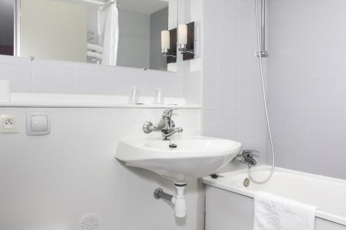 布尔日瑞斯托诺沃布尔日设计酒店的白色的浴室设有水槽和淋浴。