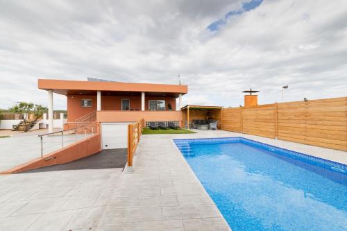 赫罗纳Piscina de sal Barbacoa Wifi, Parking Gratis, 3 min PGA Casa El Roble的围栏旁带游泳池的房子