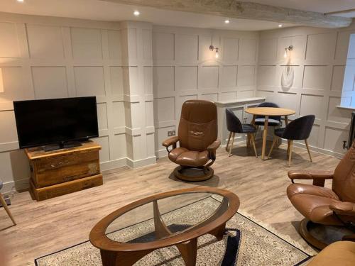 威尔汉姆Cosy Modern Cottage - Wareham的客厅配有椅子和平面电视
