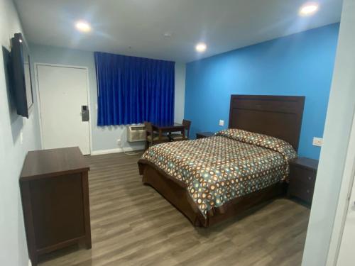 科斯塔梅萨Star Inn Motel的一间卧室设有一张床和蓝色的墙壁
