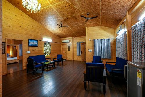 班加罗尔Brahmi Resort的一间设有蓝色椅子和桌子的等候室