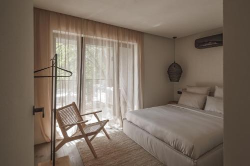 帕兰加Hill Palanga & SPA的卧室配有床、椅子和窗户。