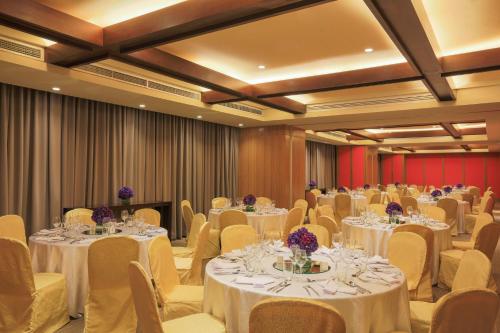 马尼拉Holiday Inn & Suites Makati, an IHG Hotel的宴会厅配有白色的桌椅