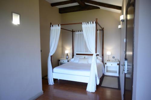伊巴兰格鲁Hotel Spa Gametxo的卧室配有带白色窗帘的天蓬床