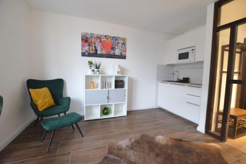 锡格堡Studio 7 City Lage mit Garage nähe Köln Bonn的一间带绿色椅子的客厅和一间厨房