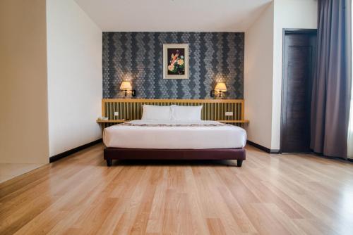 巴特沃思巴特沃思花园酒店的一间卧室配有一张床和两张带台灯的桌子。