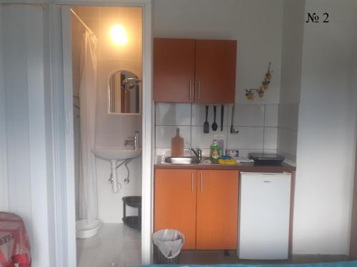 苏托莫雷OLGA apartmani的小厨房配有橙色橱柜和水槽