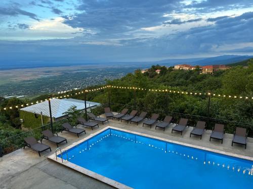 西格纳吉贝尔维尤精品酒店的一个带椅子的游泳池,享有城市美景