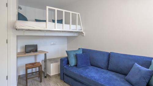 阿波罗尼亚Armenakishouses的客厅配有蓝色的沙发和一张双层床。