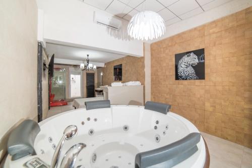 瓦伦西亚乐特莱特百斯威特旅馆的一间带椅子和吊灯的浴缸的浴室