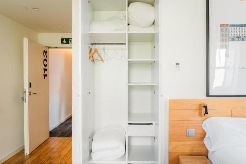 波尔图The Central House Porto Ribeira的卧室配有带白色架子的衣柜和1张床