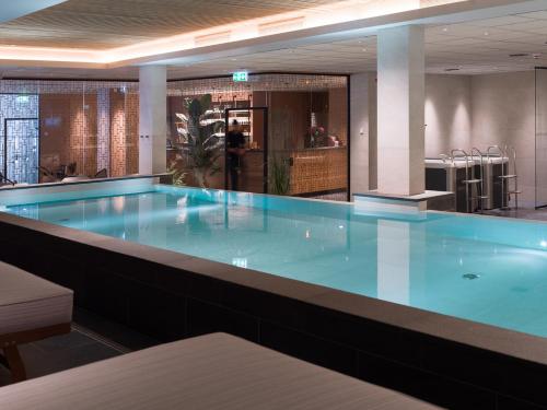 博伦厄Elite Hotel Brage - Hotel & Spa的大楼里的一个大型蓝色游泳池