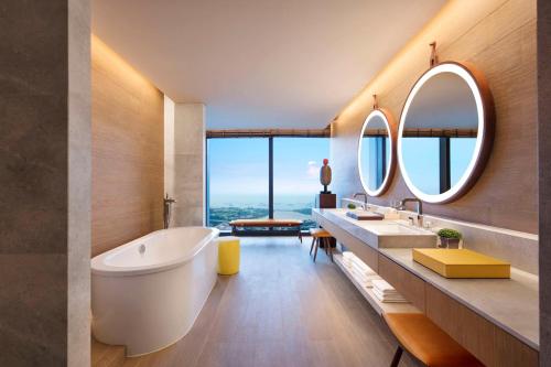 新加坡Andaz Singapore A Concept by Hyatt的带浴缸和两个盥洗盆的浴室以及大窗户。