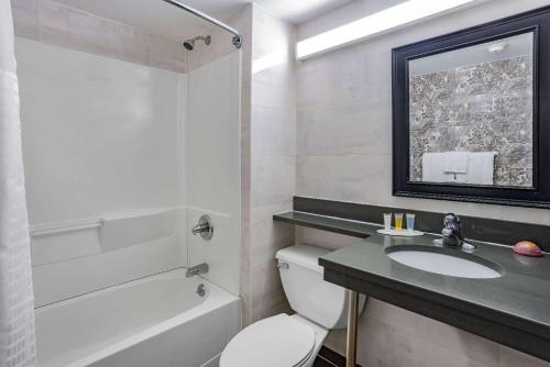 Super 8 by Wyndham Lindenhurst的浴室配有卫生间、盥洗盆和浴缸。