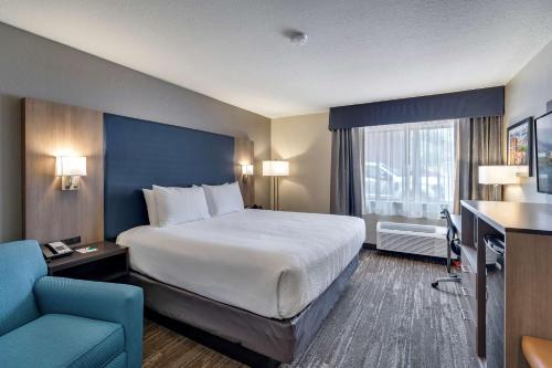 布莱斯布莱斯华美达酒店的酒店客房设有一张大床和蓝色的墙壁。