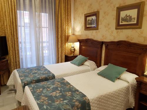 塞维利亚塞维利亚欧罗巴精品酒店的酒店客房设有两张床和窗户。