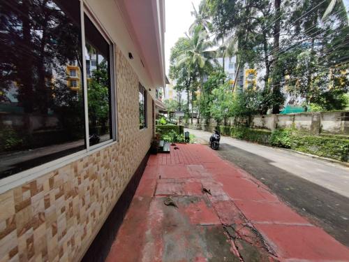古鲁瓦尤尔Fresh Up In Guruvayur Krishnendhu Residency的停在大楼旁边的人行道上的摩托车