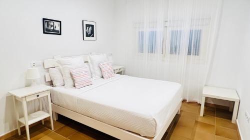 埃斯卡洛Casa Nena Es Calo的白色卧室配有白色床和白色枕头