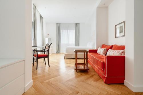 米兰Hotel Morfeo的客厅配有红色的沙发和桌子