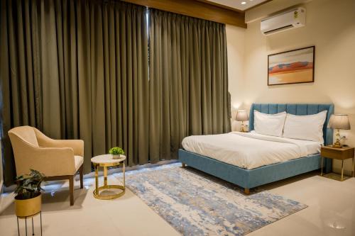 罗纳瓦拉Villa Amara 29 by Stay ALYF, Lonavala的配有一张床和一把椅子的酒店客房