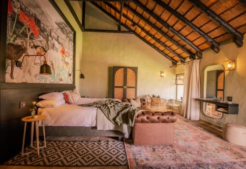 温特和克Okapuka Safari Lodge的一间卧室配有一张床和壁画墙