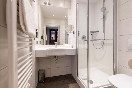帕绍Premier Inn Passau Weisser Hase的一间带水槽、淋浴和卫生间的浴室