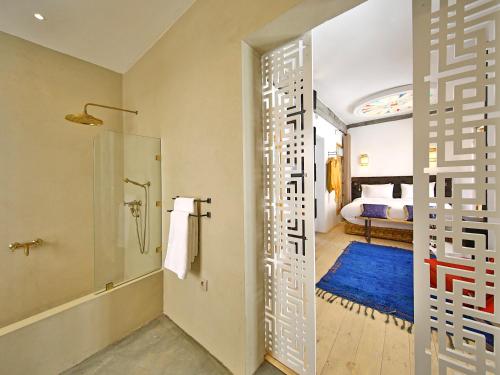 索维拉Riad EspritBleu的带淋浴的浴室和带床的玻璃门