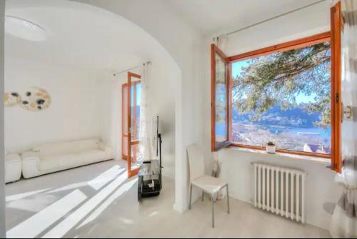 拉韦诺Apartment With View Lake Maggiore/Laveno Mombello的白色的客房设有窗户和椅子