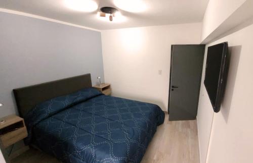 萨尔塔Nice Full Apartment Downtown Salta的一间卧室配有蓝色的床和电视