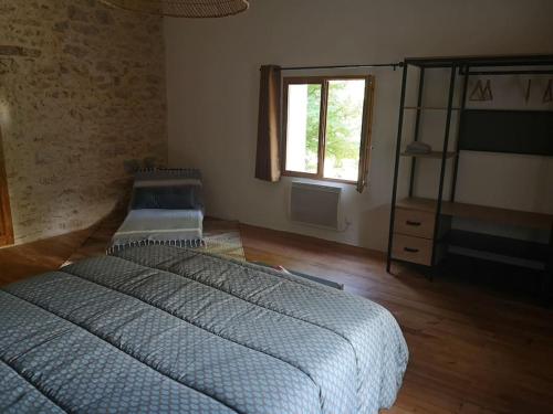 ReilhanetteGîte La Magnanerie的一间卧室设有两张床和窗户。
