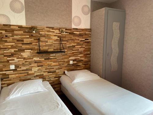 佩罗斯-吉雷克Hotel Restaurant Le Phare的一间卧室设有两张床和砖墙