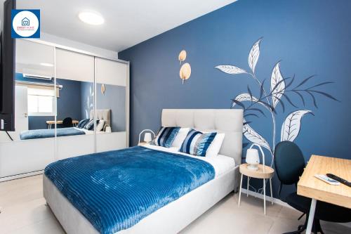内坦亚Design apartments in Netanya的蓝色的卧室,配有一张蓝色墙壁的床