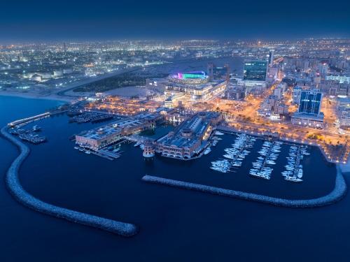 科威特Hyatt Regency Al Kout Mall的夜间海港的空中景观