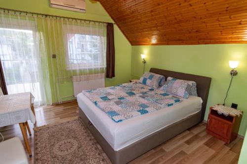 巴拉顿菲赖德蓝湖草堂旅馆的一间设有床铺的卧室,位于一个拥有绿色墙壁的房间