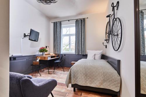 海德堡格林兹霍夫餐厅酒店的卧室配有一张床和一张桌子,墙上挂着自行车