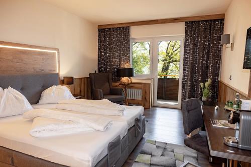 塞瓦尔兴阿特湖酒店的一间卧室配有一张床、一张书桌和一个窗户。