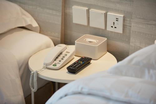 澳门澳莱大三元酒店的电话和床边桌子上的遥控器