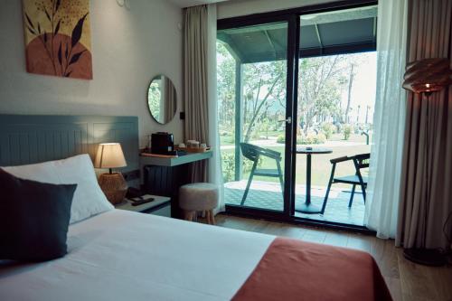 埃尔代克Parmos Otel的一间卧室配有一张床,阳台配有桌子
