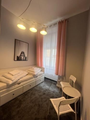 波兹南Hostel Plac Kolegiacki的卧室配有一张床和一张桌子及椅子
