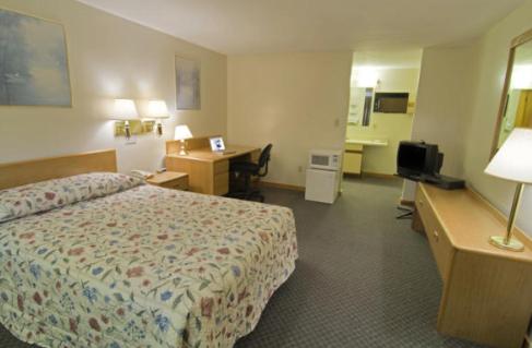 比迪福德比迪福德美国最有价值旅馆的配有一张床和一张书桌的酒店客房