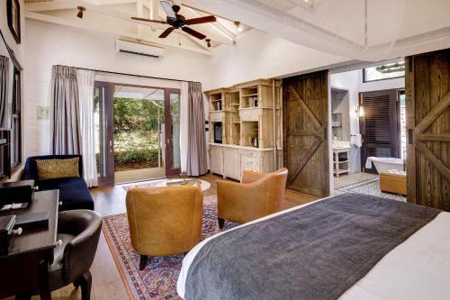 维多利亚瀑布Mbano Manor Hotel Victoria Falls by Mantis的卧室配有一张床、一张桌子和椅子