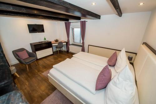 巴特德里堡祖姆布拉尼赫斯辰旅馆的卧室配有白色的床和书桌