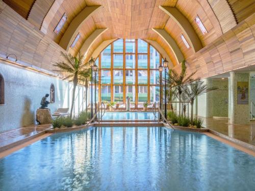 赫维兹Hotel Carbona Thermal Spa的一座大型游泳池,位于一座拥有大型天花板的建筑内