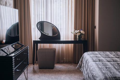 贝尔格莱德联排别墅27号加尔尼精品酒店的卧室,在床边的桌子上装有镜子