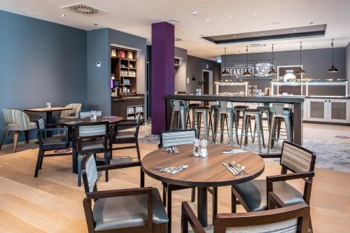 斯图加特Premier Inn Stuttgart City Centre的一间带桌椅的餐厅和一间酒吧