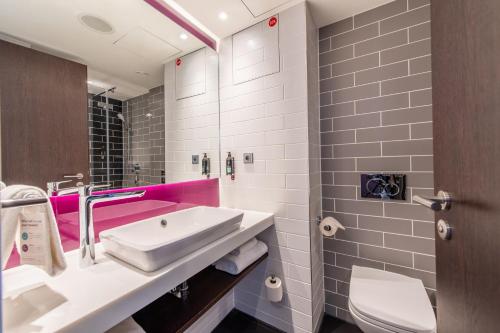 斯图加特Premier Inn Stuttgart City Centre的粉红色的浴室设有水槽和卫生间