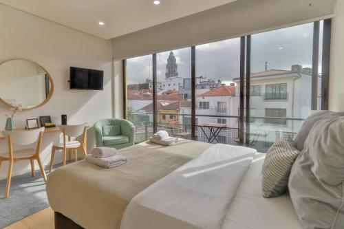 波尔图Porto Downtown Living - Picaria Apartments的一间卧室设有一张大床和一个大窗户