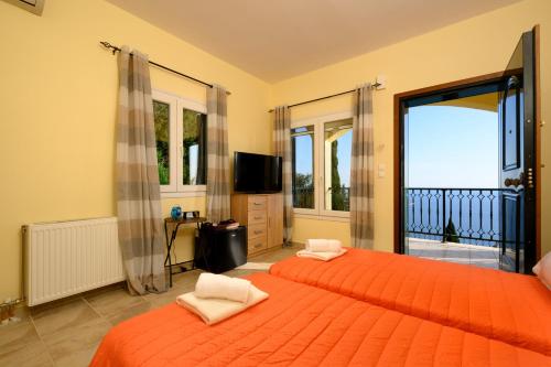 科孚镇Nisos Sunset Apartments Agios Gordios的一间卧室配有两张带橙色床单的床和电视。
